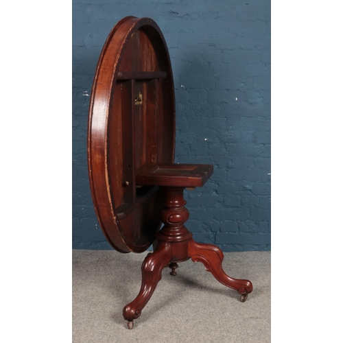 498 - A mahogany circular tilt-top table, with central pillar supported by three cabriole feet, raised on ... 