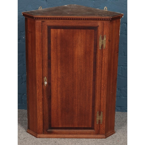 510 - A George III oak corner wall mounted corner cupboard. 90cm.