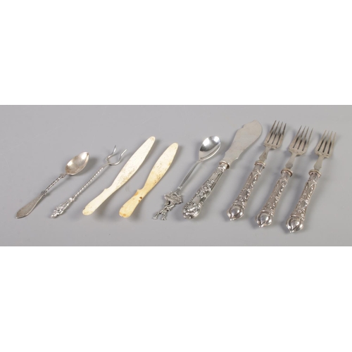 108 - A collection of antique cutlery. Includes silver handled and white metal examples, bone peelers etc.