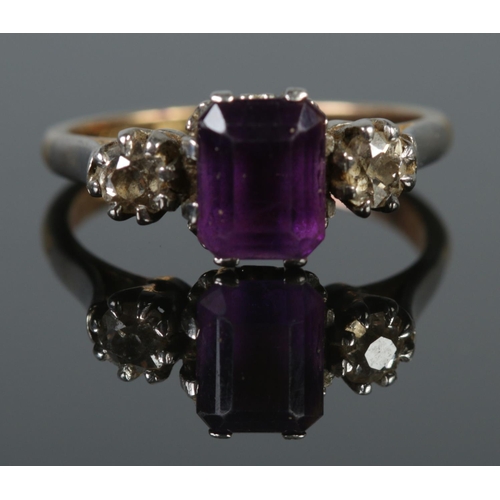 127 - An 18ct gold and platinum ring set with a single square cut amethyst flanked by two diamonds. Size N... 