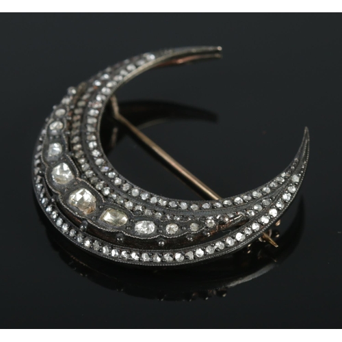 131 - A vintage crescent formed brooch set with rough cut diamonds. Approximately 4.5cm x 4.5cm. Largest d... 