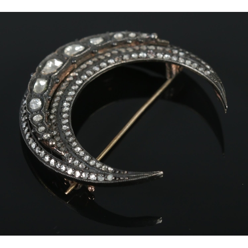 131 - A vintage crescent formed brooch set with rough cut diamonds. Approximately 4.5cm x 4.5cm. Largest d... 