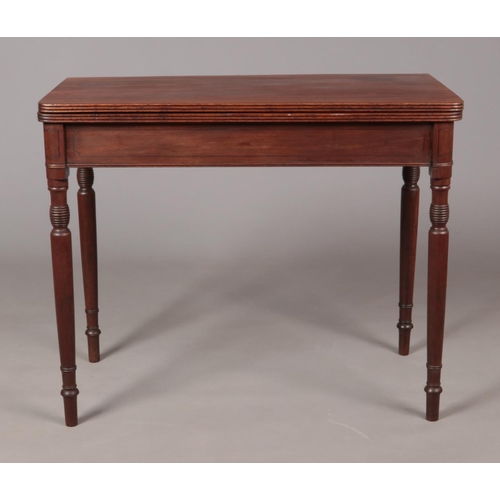 177 - A Georgian mahogany fold over tea table with turned supports.