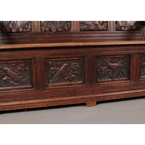 179 - A 19th century extensively carved oak settle. The four back panels depicting farming scenes through ... 