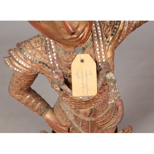 187 - A large Thai wooden dancing figure decorated with gilt and jewels. 106cm.