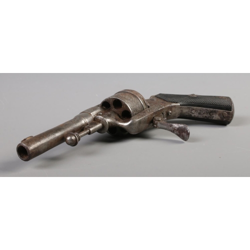 58 - A late 19th/early 20th century pin fire revolver with engraved six shot cylinder and chequered grip.