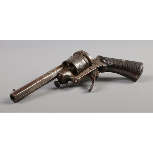 59 - A late 19th/early 20th century pin fire revolver with engraved six shot cylinder and chequered grip.