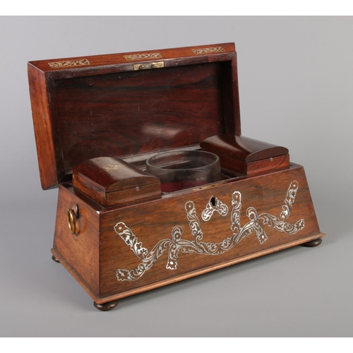 72 - A Victorian tea caddy of sarcophagus form, having mother of pearl inlay and brass loop handles.