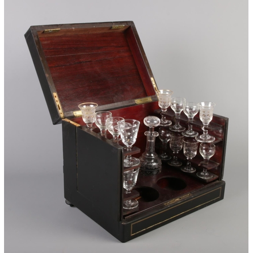 76 - A 19th century ebonised table top liqueur cabinet, having hinged top, sides and front. Housing a qua... 