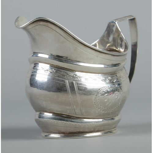 93 - A Georgian silver cream jug with engraved decoration. Assay mark for Newcastle. 110g.