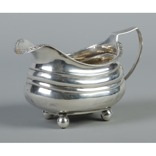 98 - A George III silver cream jug raised on four ball feet. Assayed London 1813. 114g.