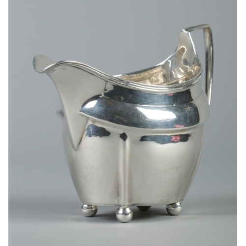 99 - A George III silver cream jug raised on four ball feet. Assayed London 1805 by Peter, Ann & William ... 