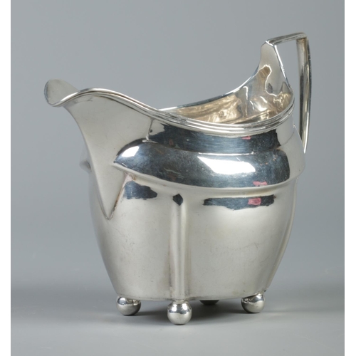 99 - A George III silver cream jug raised on four ball feet. Assayed London 1805 by Peter, Ann & William ... 