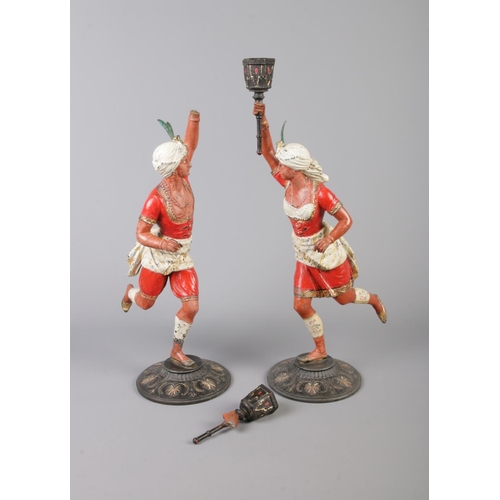 39 - A pair of cold painted spelter figural candlesticks, modelled as Turks holding torches. 39cm.