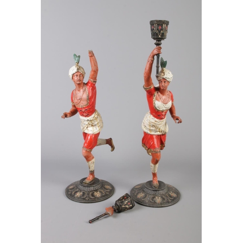 39 - A pair of cold painted spelter figural candlesticks, modelled as Turks holding torches. 39cm.