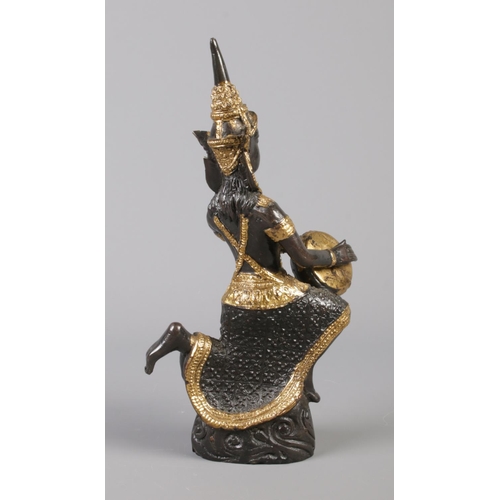 42 - A cast bronze sculpture formed as a Thai musician, with gilt decoration. 19cm.