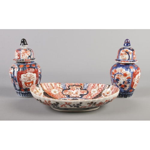 51 - A Japanese Imari fluted oval dish along with a pair of similar lidded vases.