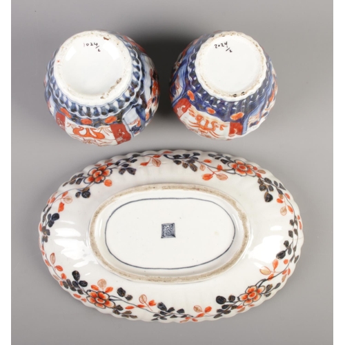 51 - A Japanese Imari fluted oval dish along with a pair of similar lidded vases.