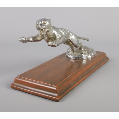 31 - A vintage Desmo white metal car mascot formed as a Jaguar, raised on mahogany plinth. Length of plin... 