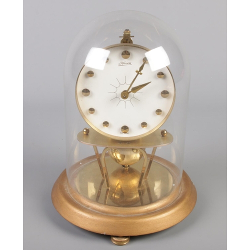 201 - A West German Kaiser torsion clock under glass dome with globe pendulum.