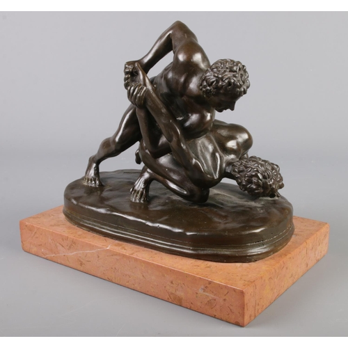 203 - After Tupton, a bronze sculpture, The Wrestlers, raised on marble plinth. 23cm.