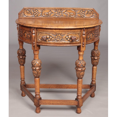 545 - A small oak demi lune side table with carved ornate floral decoration.