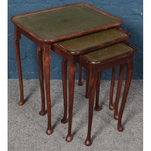 567 - A nest of three leather top tables.