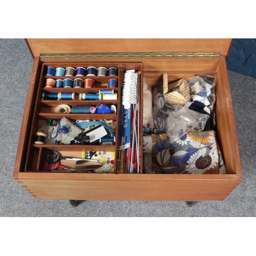 581 - A teak sewing box with contents.