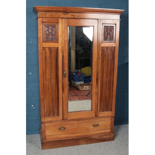 594 - An Edwardian carved mahogany  two piece bedroom suite. Comprising of mirror front wardrobe and dress... 