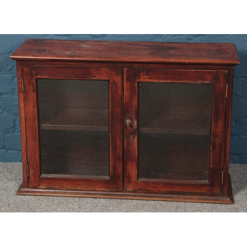 598 - A mahogany table top cabinet with glass doors. (57cm x 86cm)