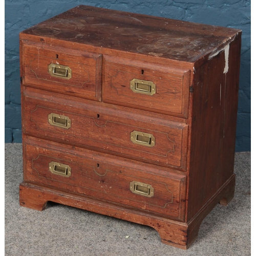 601 - An early 20th century oak apprentice chest of two over two drawers. With brass inset handles and bra... 