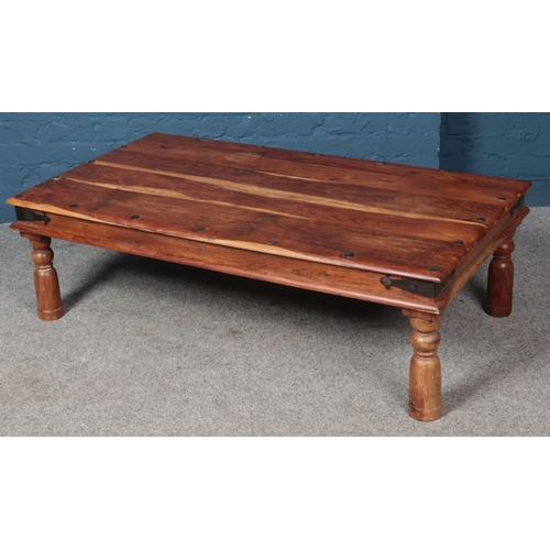 602 - A metal bound hardwood coffee table. (40cm x 136cm)