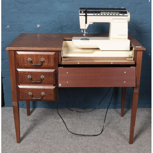 607 - An oak sewing table housing a Singer Futura electric sewing machine.