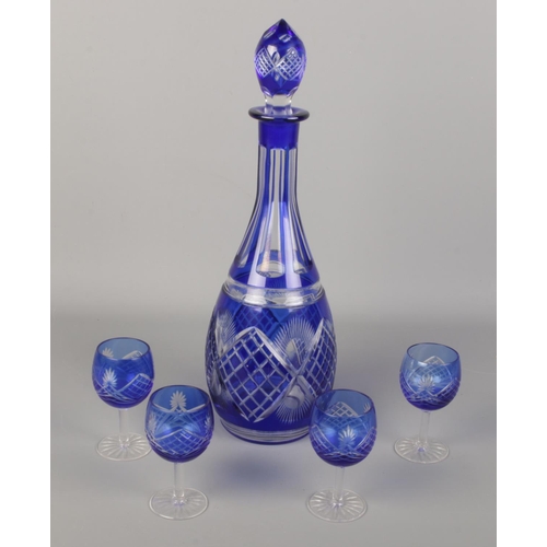 105 - A blue glass flash cut decanter along with four matching glasses.