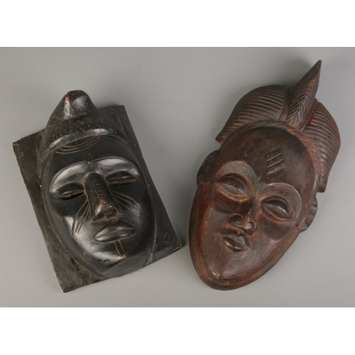 128 - Two African carved wood tribal masks.