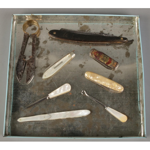 131 - A tray of collectables. Includes mother of pearl page turner with folding knife, cut throat razor, R... 