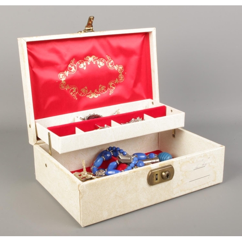 159 - A cream cantilever jewellery box, containing an assortment of costume jewellery, including brooches,... 