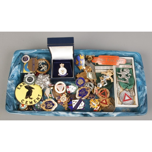 163 - A large collection of enameled badges, cap badges and medals.