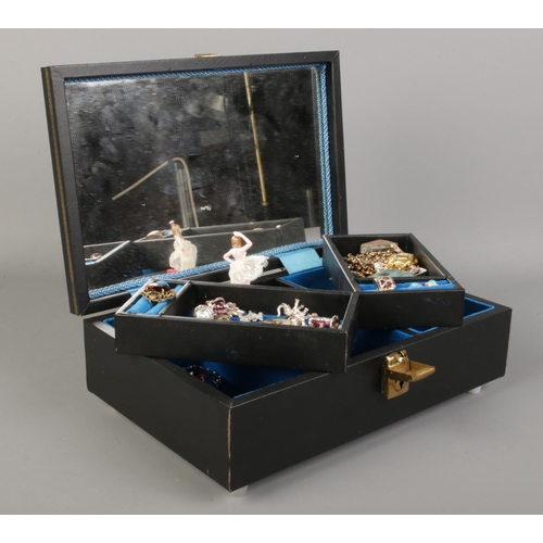 165 - A musical jewellery box containing an assortement of costume jewellery; including white metal charms... 