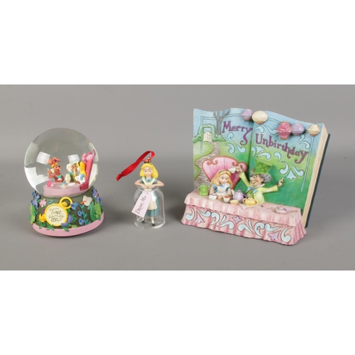 187 - A quantity of Disney's Alice In Wonderland figures including storybook scene and snow globe etc.