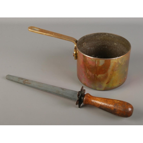 198 - A Victorian brass and copper pan along with a wooden handled knife sharpener marked carborundum.