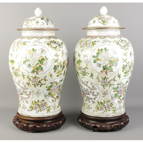 2 - A pair of mid 20th century Chinese lidded baluster vases, raised on carved hardwood stands. Bears si... 