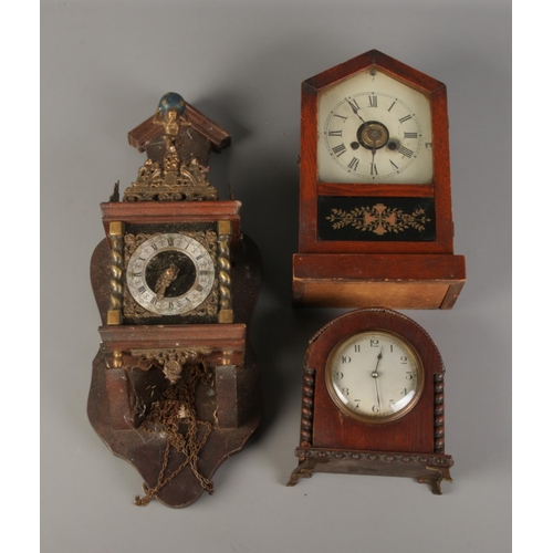 204 - A Dutch wall clock featuring figure of Atlas with German eight day movement. Also two mantle clocks.