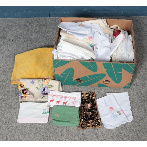 214 - A box of assorted linens including embroidered, lace and velvet examples.