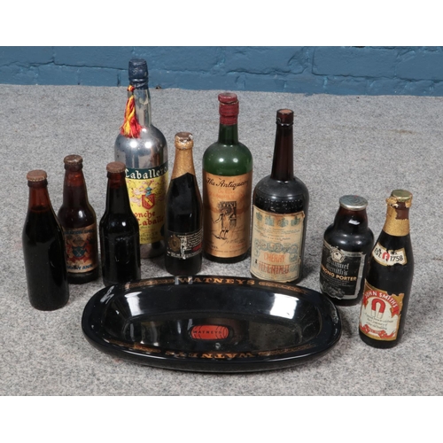 265 - A box of assorted bottled alcohol and a Watney's pottery tray.