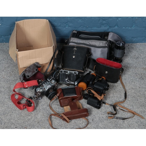 267 - A box of cameras and binoculars. Including Agfa Isolette bellows camera, Canon AV-1 camera, etc.