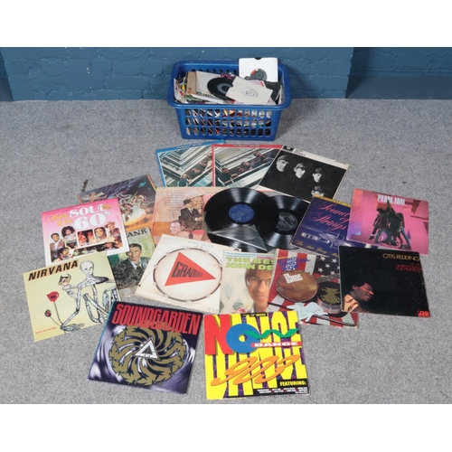 297 - A box of LP and single records. Including The Beatles, Madness, Billy Joel, Blondie, etc.