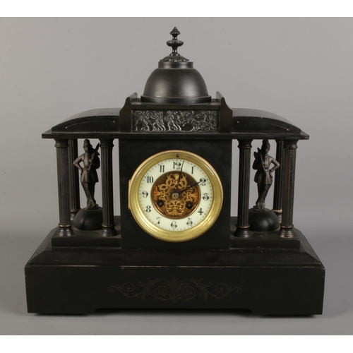 36 - A black slate mantel clock, formed as a Roman colosseum, with Corinthian pillars surrounding soldier... 