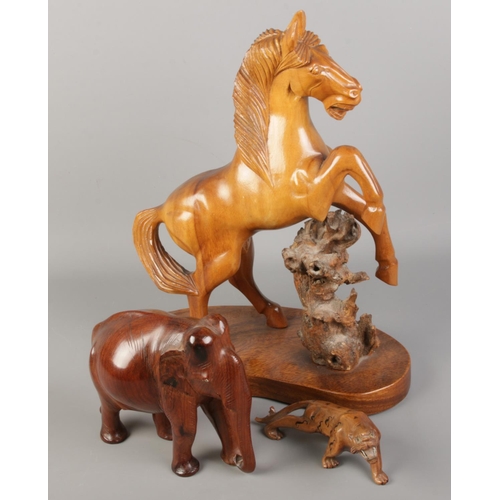 46 - Three wooden figures. Including large rearing horse, elephant and a tiger.