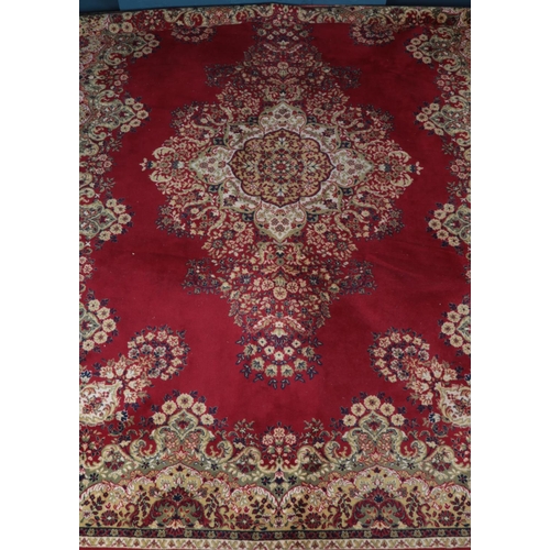 310 - A large red ground carpet with floral decoration. (396cm x 300cm)